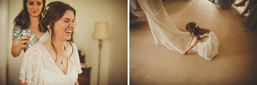 The bride laughs as a bridesmaid places the veil onto the back of the brides hair