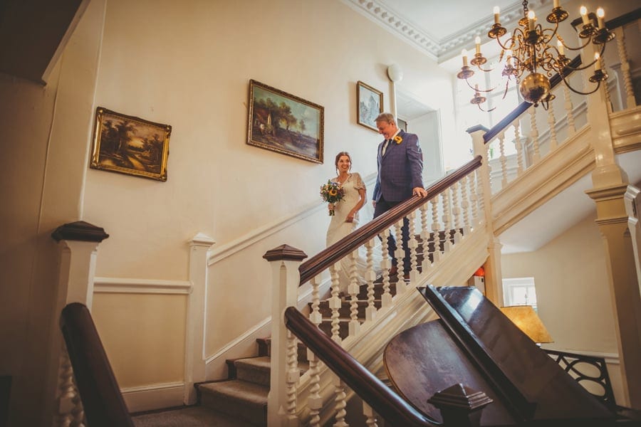 The bride and her father walking down the main staircase at Barley Wood house