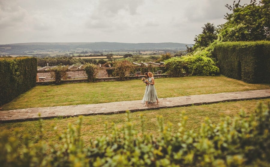 Bridesmaids walking across the path towards the outdoor ceremony