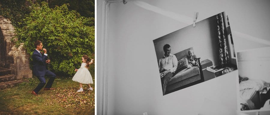 The groom plays with the flower girl and a black and white photograph hangs hangs from a ribbon