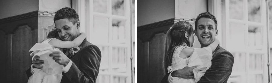 The groom delivers his speech holding the flower girl in his arms