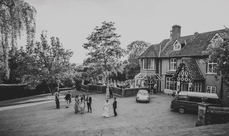 The bride and groom with their wedding guests at the front of Barley Wood house in Bristol