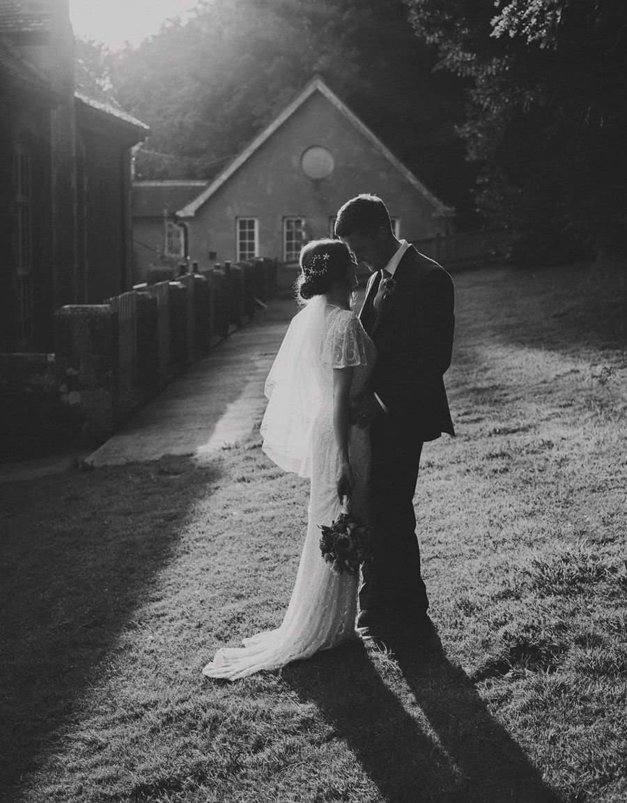 The groom looks closely into the eyes of the bride at the side of Barley Wood House in Wrington