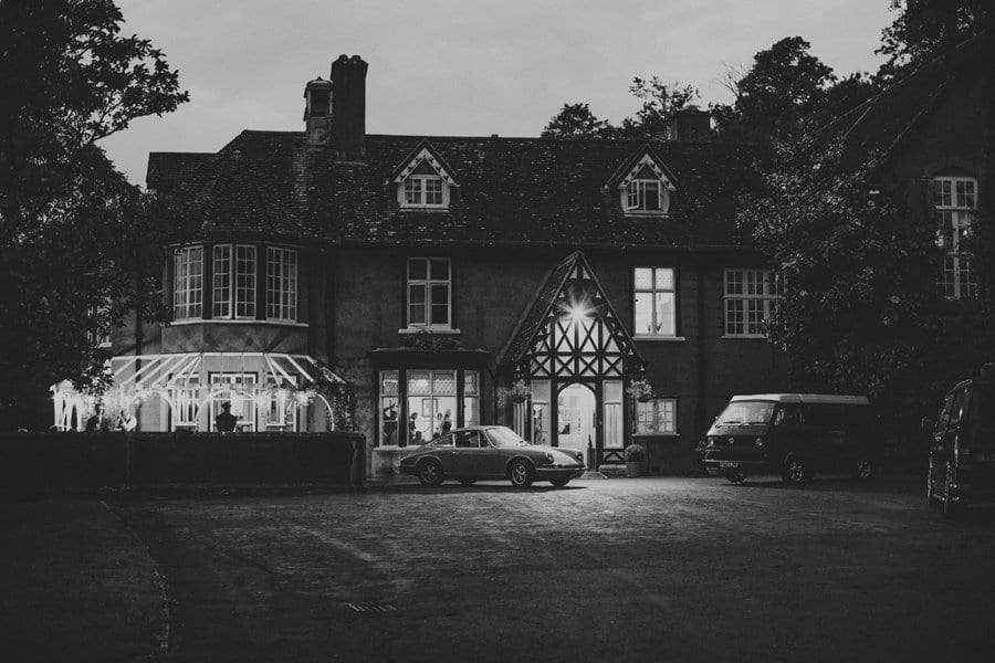 A car and a van parked outside the front of Barley Wood house late in the evening