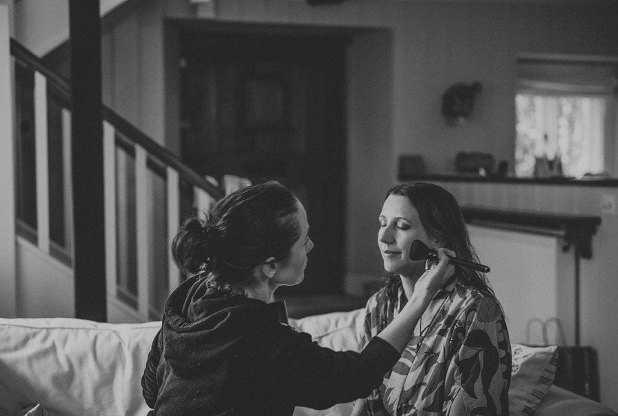 The make up artist applies mascara to the brides cheek