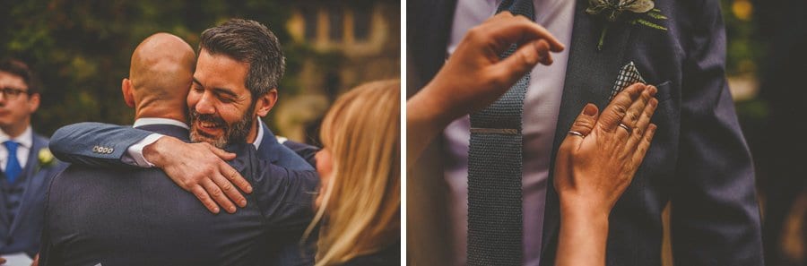 Wedding guests arriving and a lady folds a handkerchief into the breast pocket of an ushers suit
