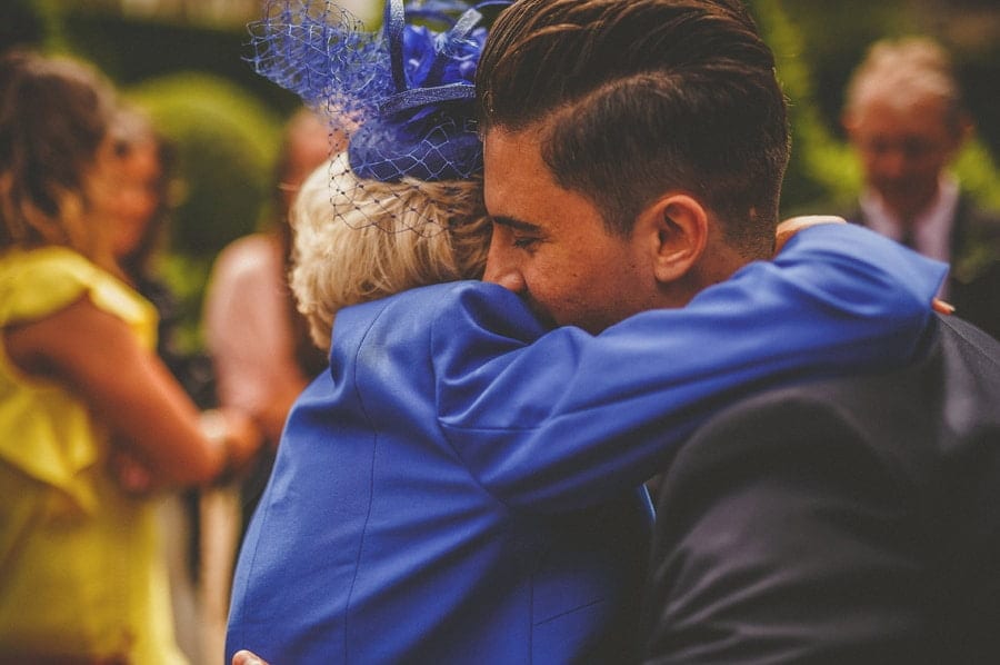 The grooms mother hugs a family member