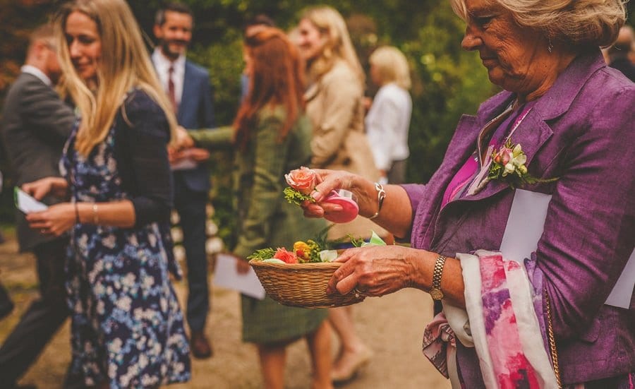 A lady holds a flower in her hand
