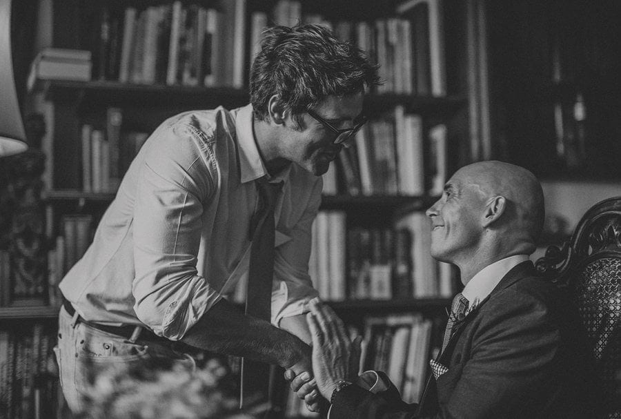 A wedding guest shakes the hand of the groom during the wedding ceremony