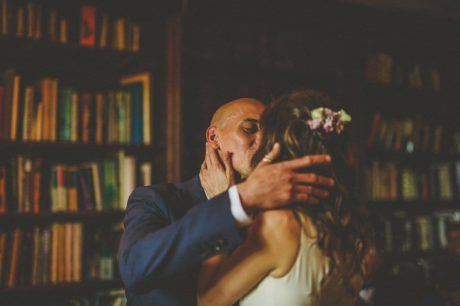 The bride and groom hold each other and kiss during the wedding ceremony