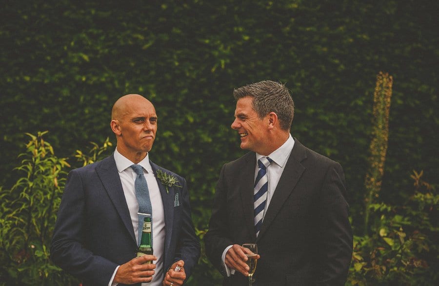 The groom talks with a wedding guest