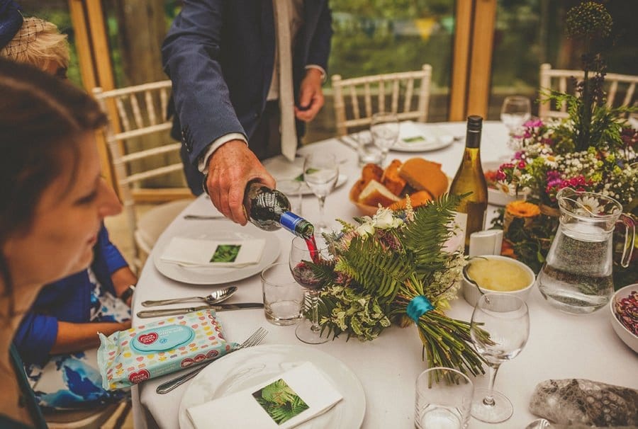 The groom pours the bride a glass of red wine