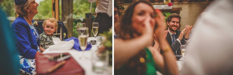 The bride and groom's son laughs as he sits on the lap of his grandmother