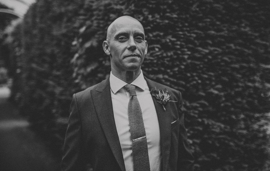 The groom poses for a photograph