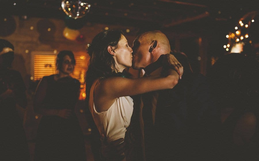 The bride kisses the groom on the dancefloor