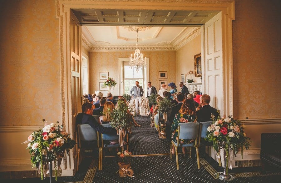 The bride and best man stand and wait for the bridal party with friends and family