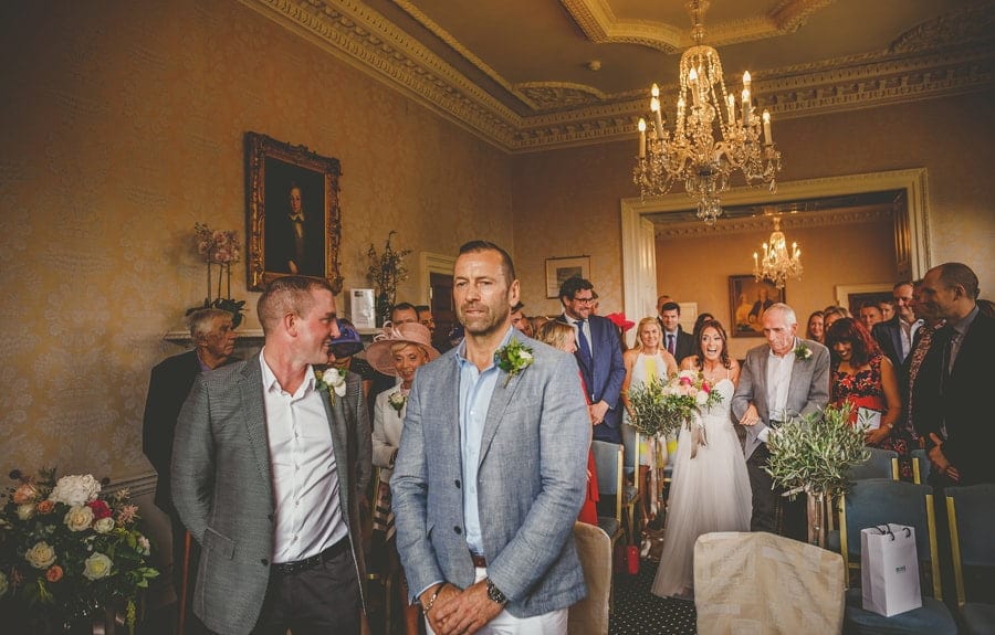The groom waits for the bride to walk down the aisle with her father
