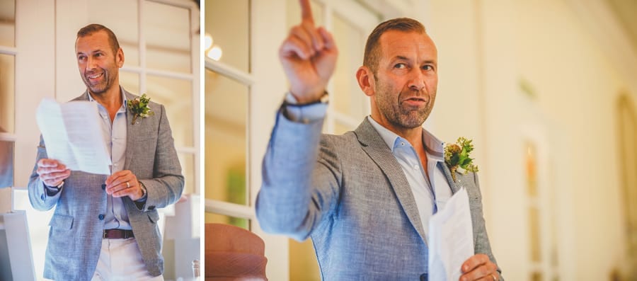The groom points to the ceiling and delivers his speech to the wedding party