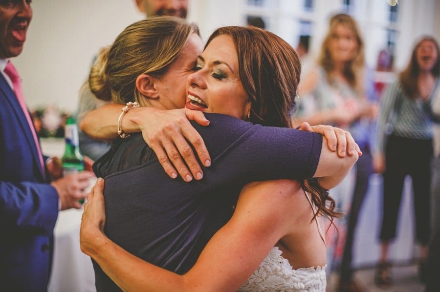 The bride puts her arms around her best friend on the dancefloor