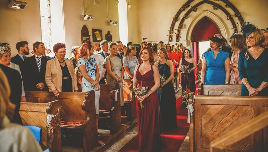 Bridesmaids walking down the aisle of the Church towards the groom