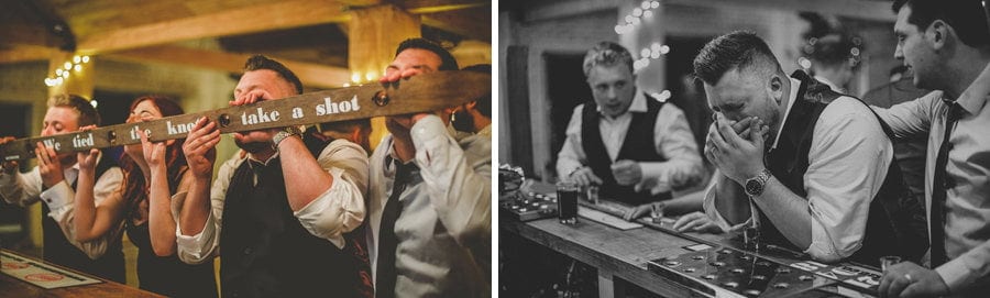 The groom and his ushers drink alcoholic shots at the bar in Eden Barn