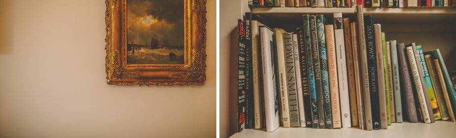 Books on a bookshelf and a framed oil painting hangs on a wall
