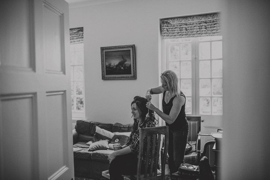 The hairdresser attends to one of the bridesmaids