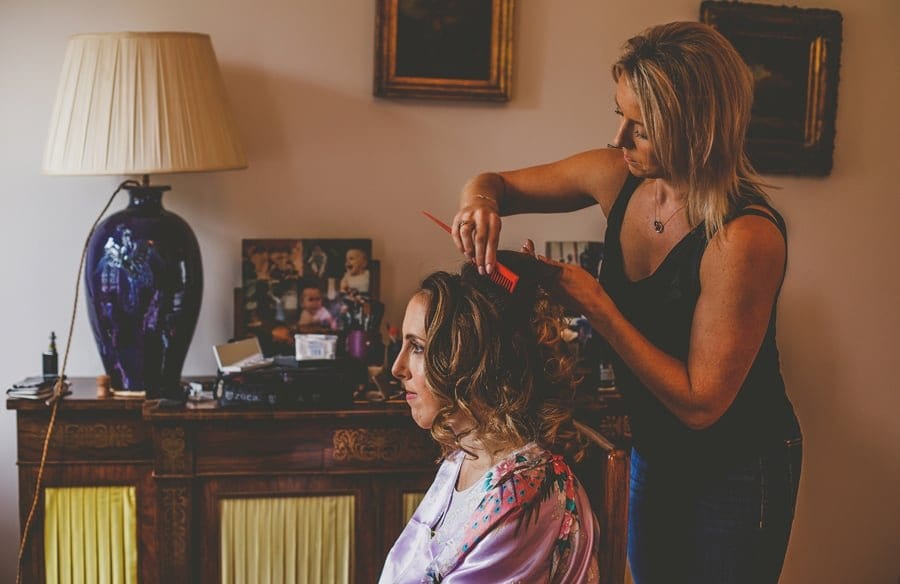 The hairdresser combs the bride's hair