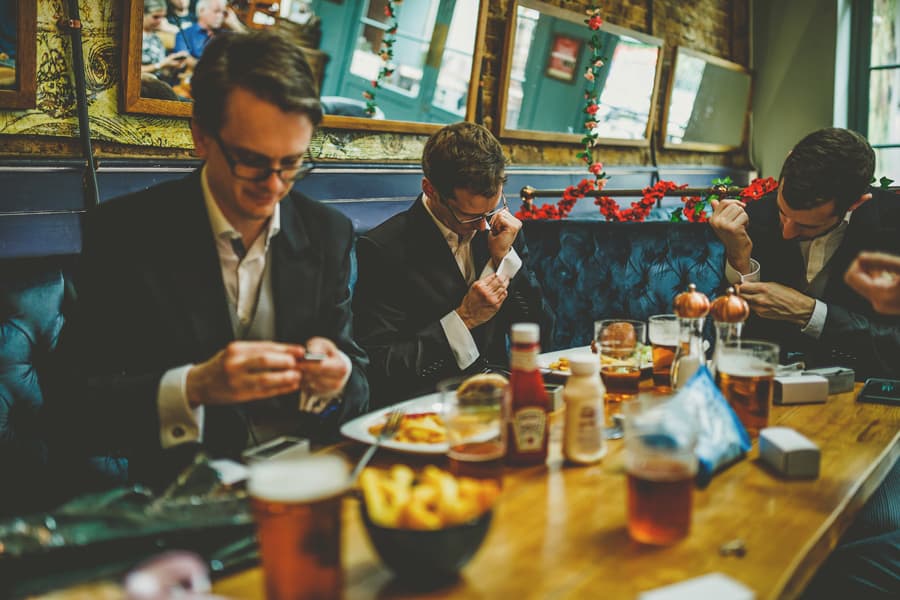 The ushers sit at a table and fasten their cufflinks