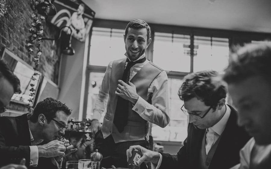 An usher stands up and smiles at the groom in the Kings Arms public house in Fulham