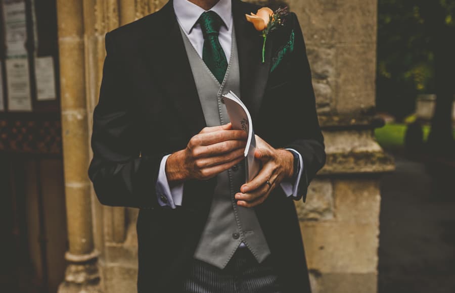 An usher holds an order of service in his hands outside the Church