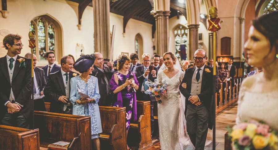 The bride and her father walk up the aisle of the Church together