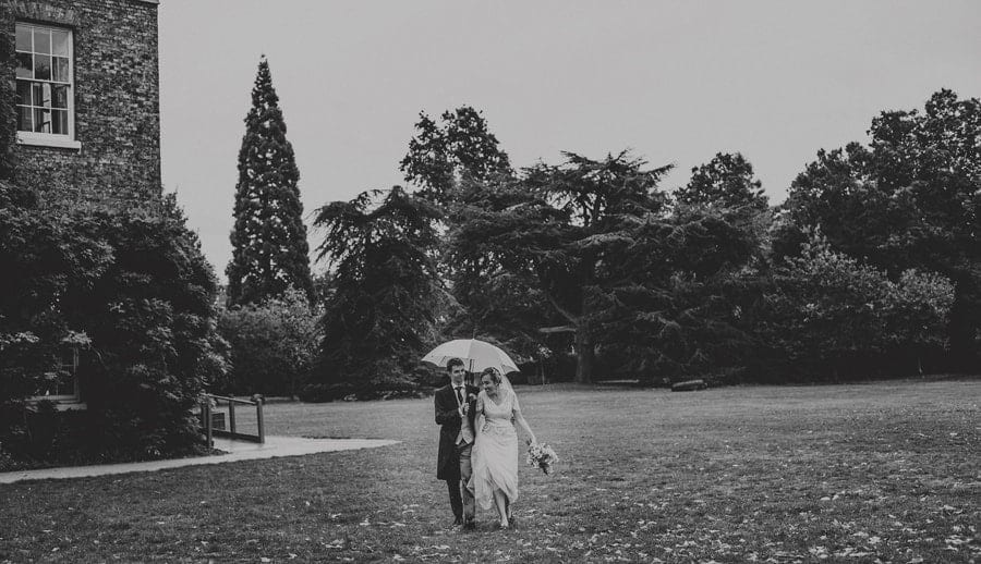 The bride and groom walk through the gardens at Fulham Palace