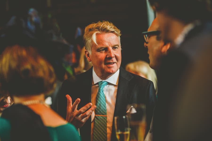 A wedding guest chats with a friend at Fulham Palace