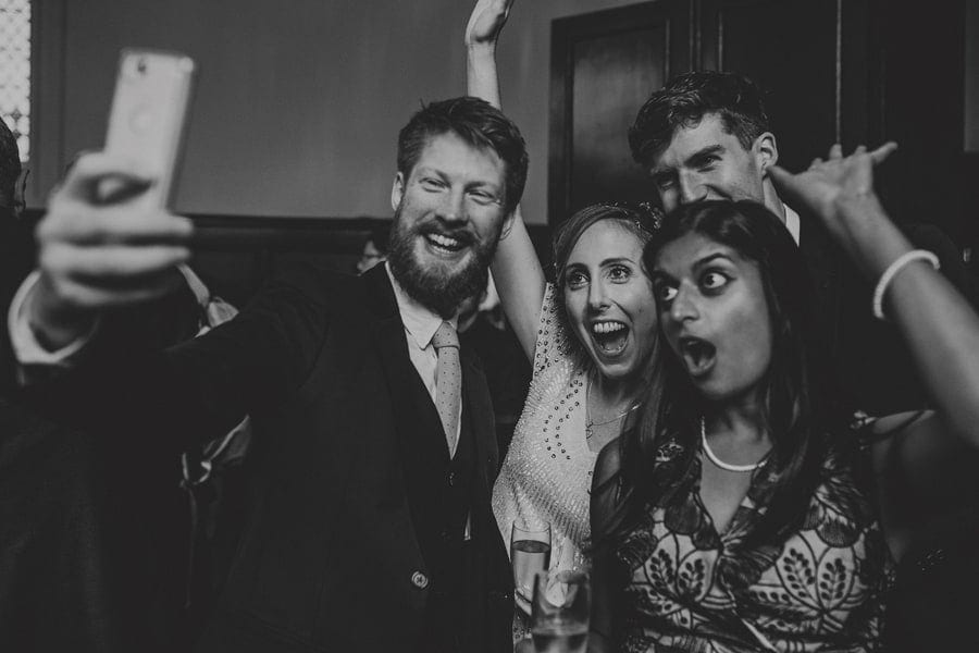 The bride poses for a photograph with friends at Fulham Palace