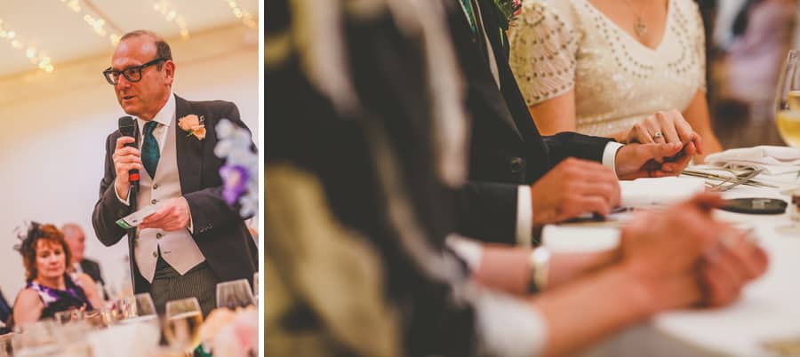 The bride and groom hold hands as they listen to the brides fathers speech
