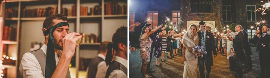 The bride and groom walk through the courtyard at Fulham Palace in front of their wedding guests