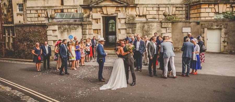 Friends and family congratulate the bride and groom outside Goldney Hall