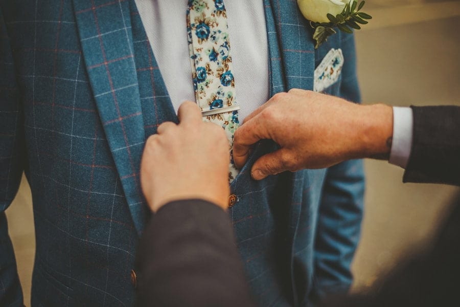 The groom's brother straightens his waiscoat