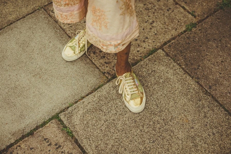 A wedding guests gold coloured shoes