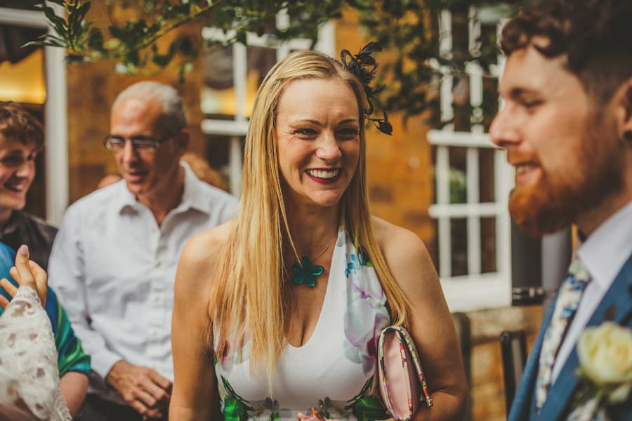A wedding guest talks to the groom