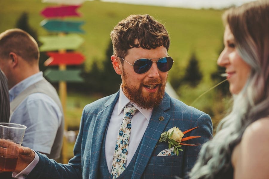 The groom talks to a wedding guest