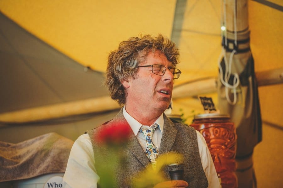 The grooms father closes his eyes during his speech in the tipi