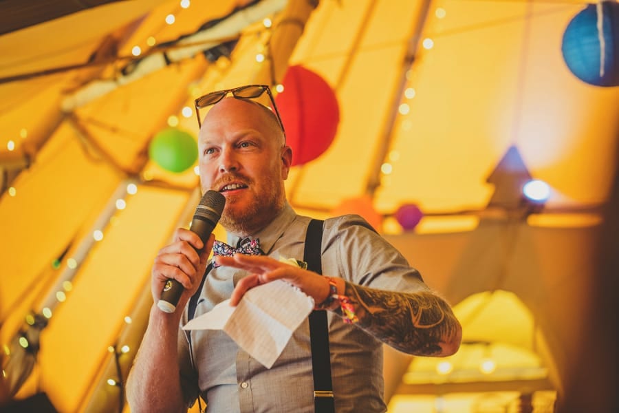 The best man stands up in the tipi at Hadsham Farm and delivers his speech