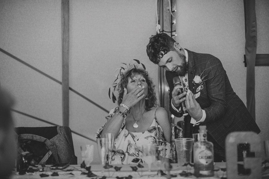 The groom shows his mother a ticket as she blows a family friend a kiss