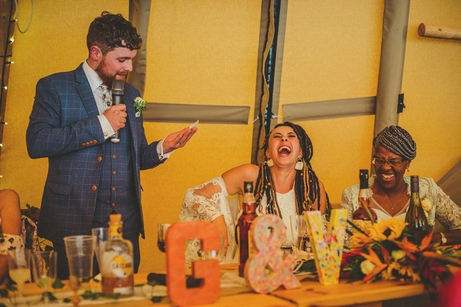 The bride and her mother laugh at a joke told by the groom