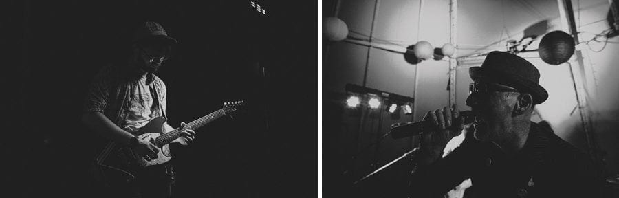 The guitarist of the wedding band plays his guitar and the singer sings into a microphone