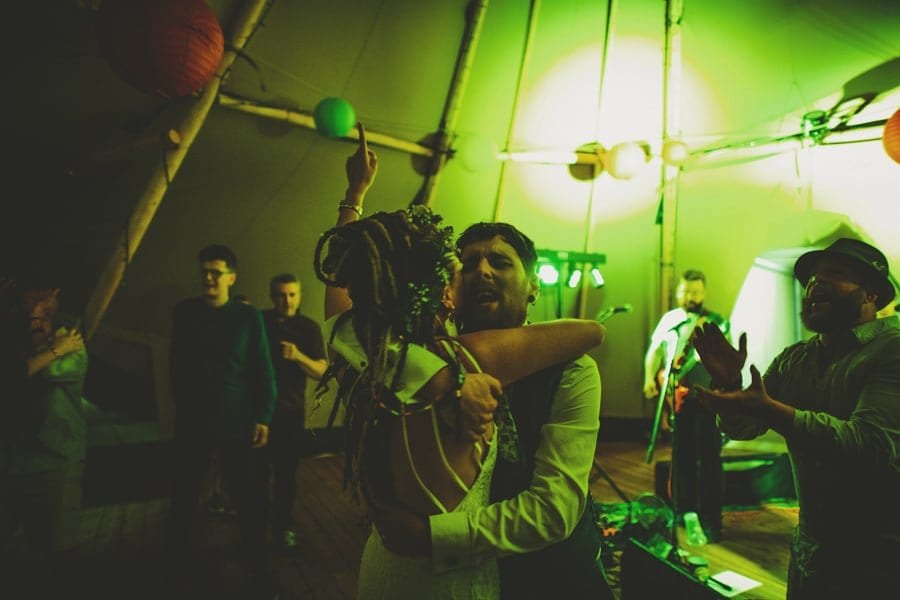 The bride and groom embrace each other on the dancefloor