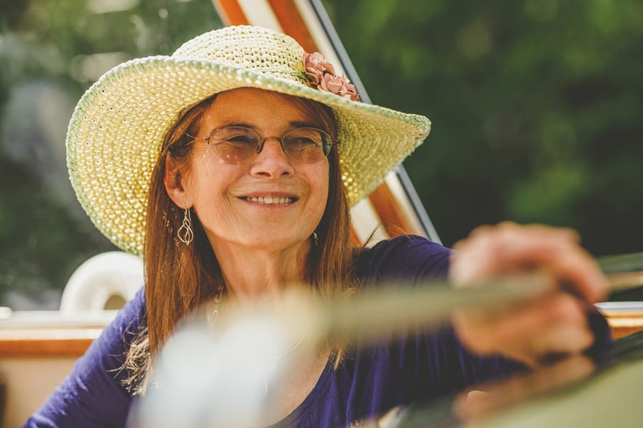 A wedding guest sits in the boat and listen to friends and family chatting