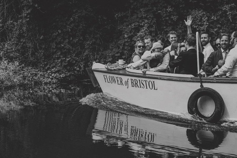 Wedding guests wave on another wedding boat on the canal in Bristol